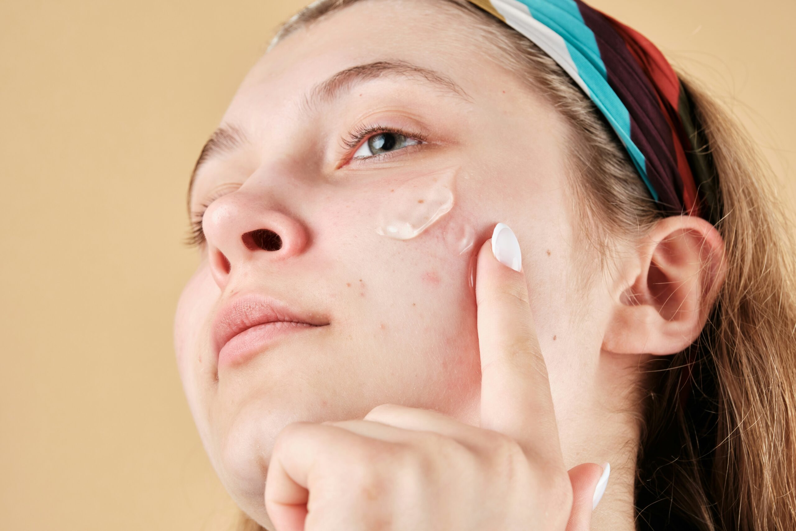 Woman showing natural skin and applying a product