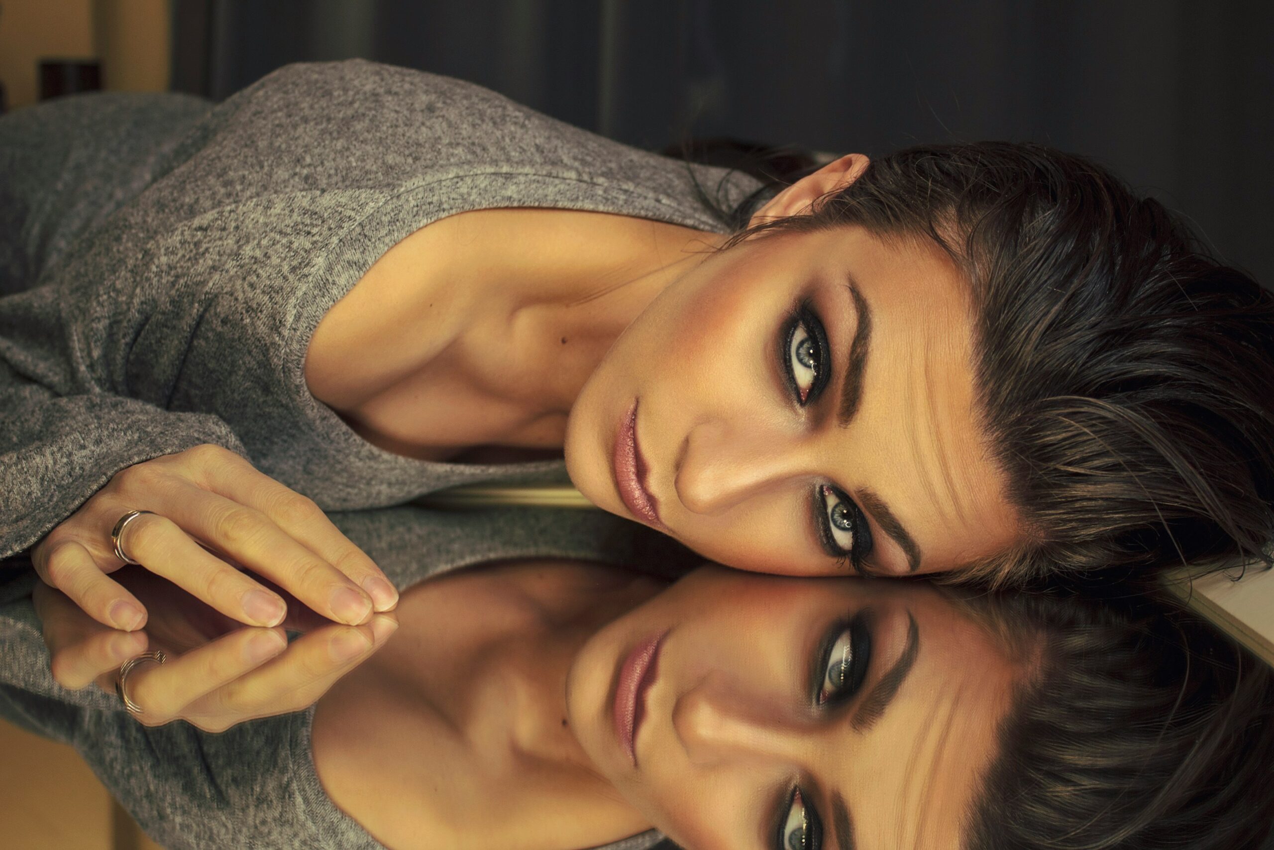 Model with smokey eyes against a mirror