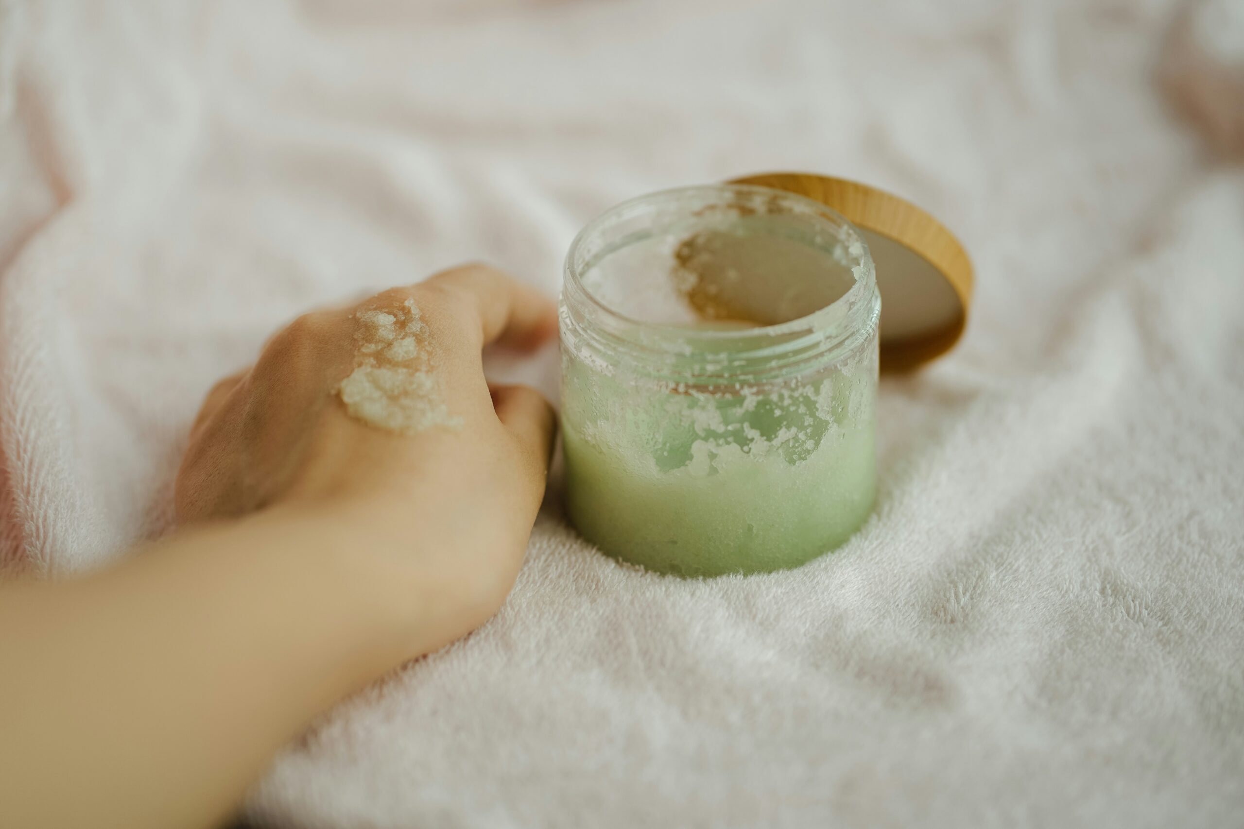 A hand showing a body scrub cream