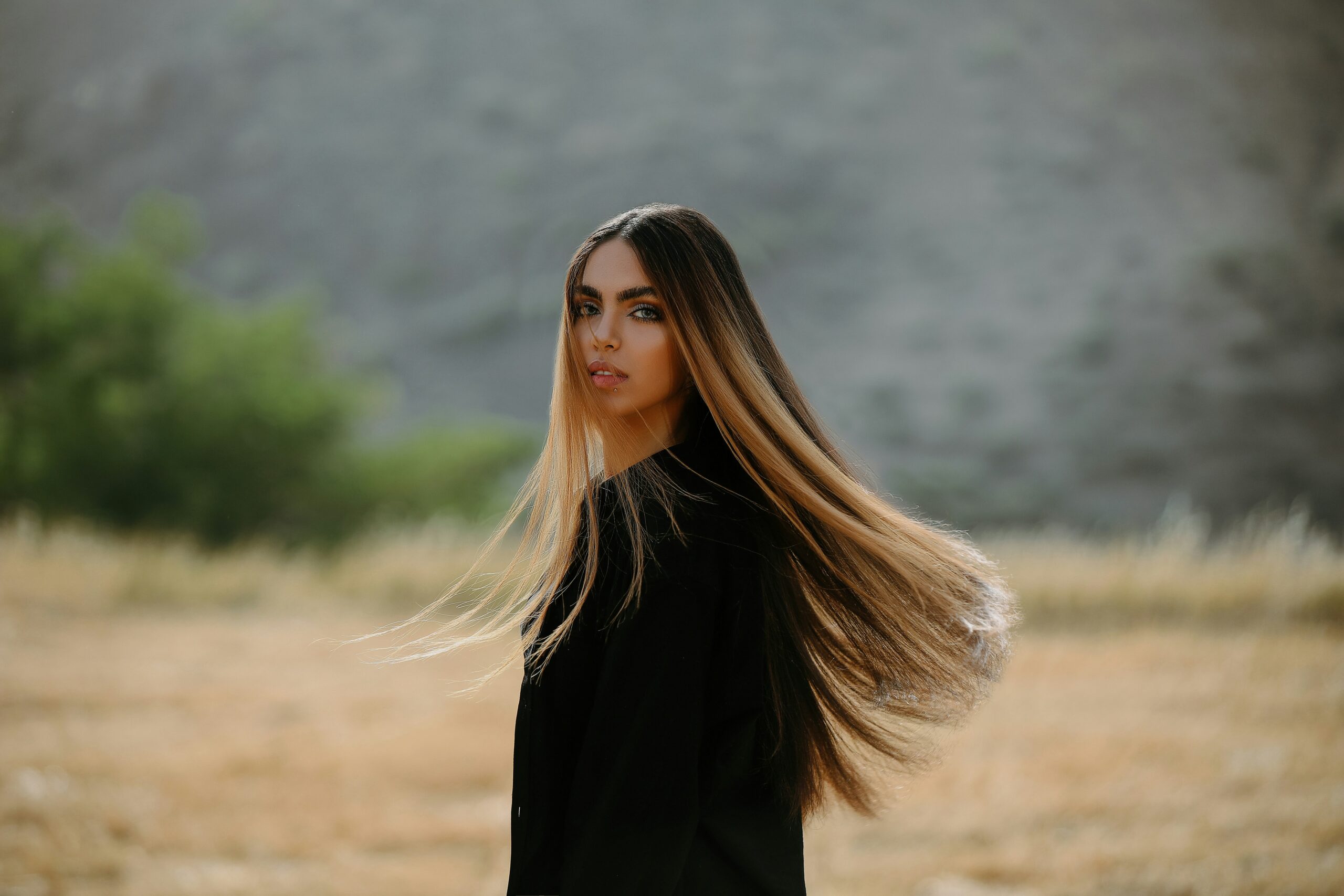 Woman on a landscape waving her hair